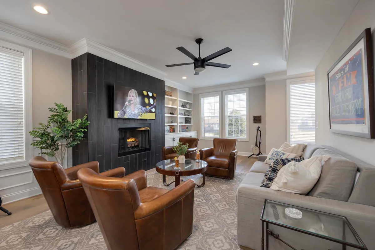 This image highlights the living area featuring a comfortable seating arrangement centered around a fireplace and smart TV. Vintage-inspired décor and a decorative plant add character and warmth to the space, making it feel both welcoming and stylish.